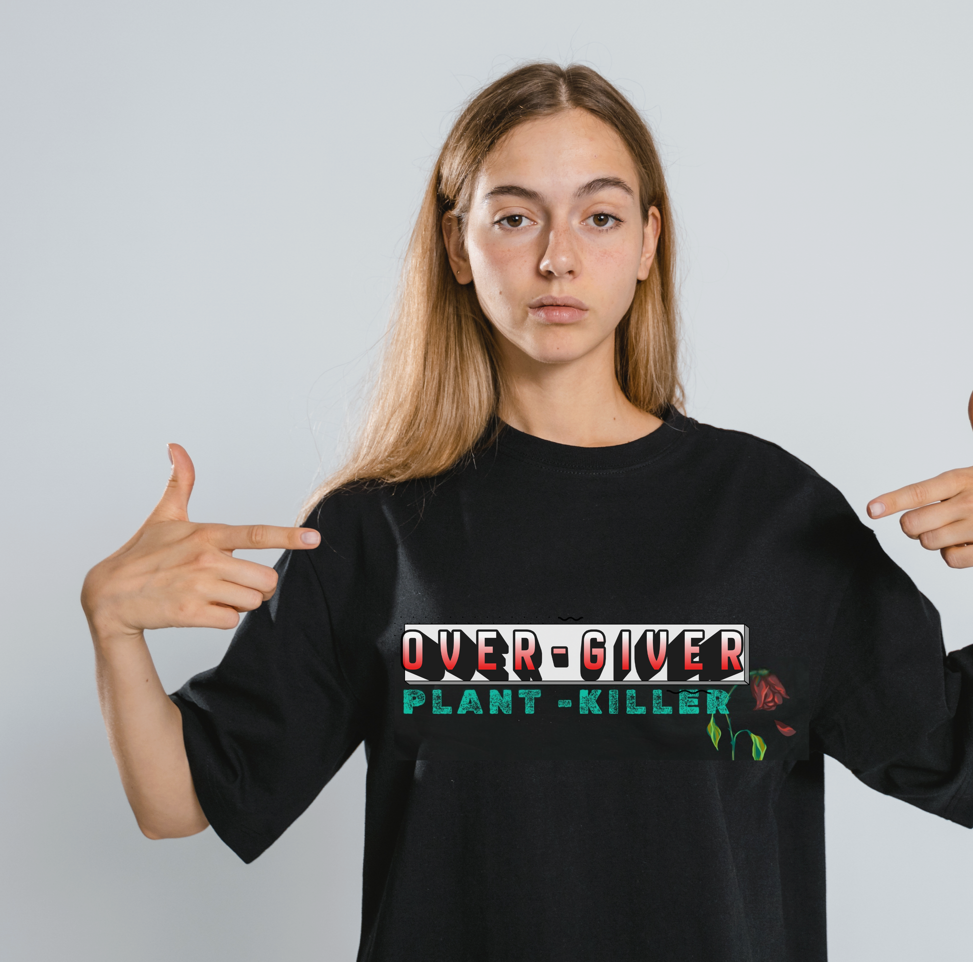 Person wearing a black t-shirt with 'OVER-GIVER PLANT-KILLER' text and pointing at it.